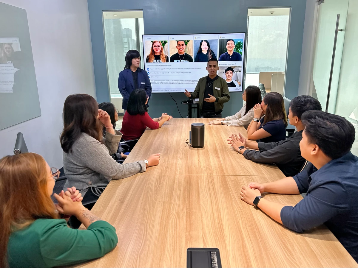 Woolworths MarketPlus team leaders reviewing an escalations and customer satisfaction dashboard on the office TV